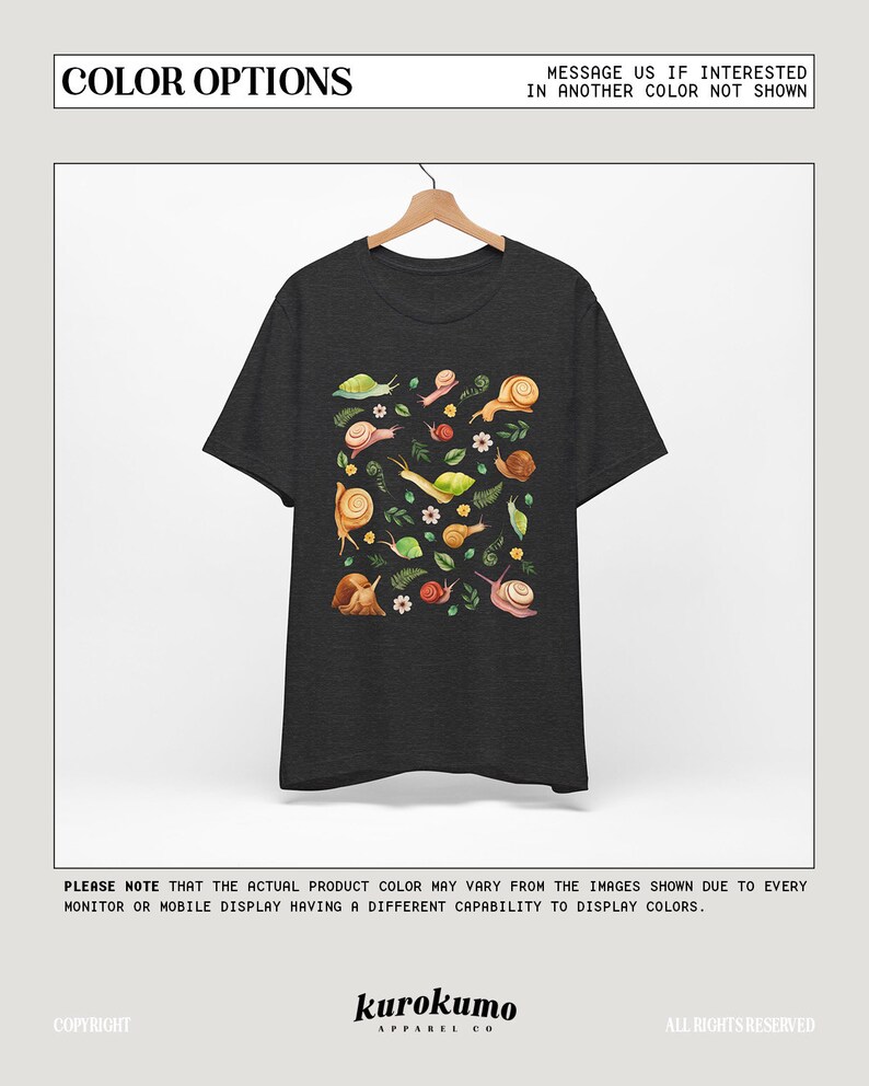 May include: A dark heather grey t-shirt with a colorful graphic print of snails and leaves. The text "COLOR OPTIONS" is at the top of the image and the text "MESSAGE US IF INTERESTED IN ANOTHER COLOR NOT SHOWN" is at the top right of the image. The text "kurokumo APPAREL CO" is at the bottom of the image.