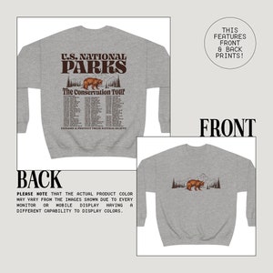May include: Gray sweatshirt with a front graphic featuring "U.S. National Parks" and a bear illustration. The back of the sweatshirt also has a bear and mountain graphic. The text "The Conservation Tour" is also on the front.