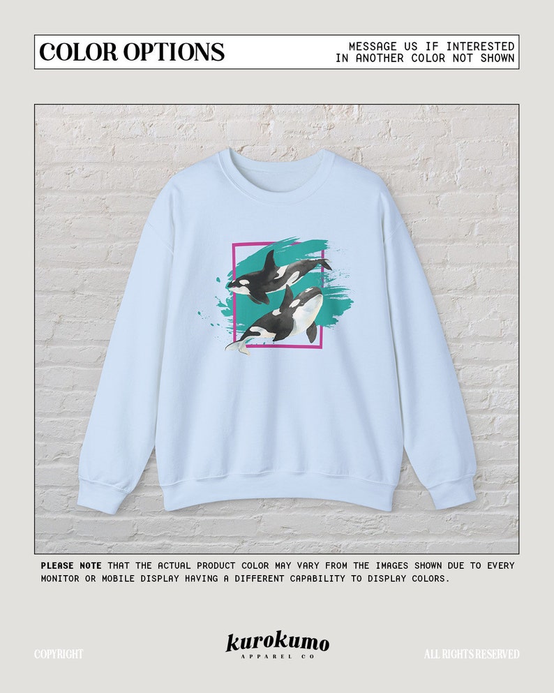Puede incluir: Sudadera azul claro con un gr&aacute;fico de dos orcas nadando en un dise&ntilde;o abstracto turquesa y verde azulado. El dise&ntilde;o est&aacute; enmarcado en un rect&aacute;ngulo negro y rosa.