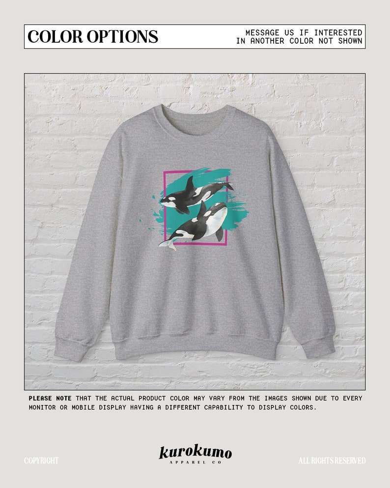 Puede incluir: Sudadera gris con un estampado gr&aacute;fico de dos orcas nadando en agua turquesa. Las orcas son negras y blancas con un contorno rosa alrededor del gr&aacute;fico.