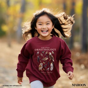 May include: A maroon sweatshirt with the text "Study of Birds ORNITHOLOGY" and various bird illustrations. The sweatshirt is part of the "Natural History Collection". The word "MAROON" is printed on the bottom right.