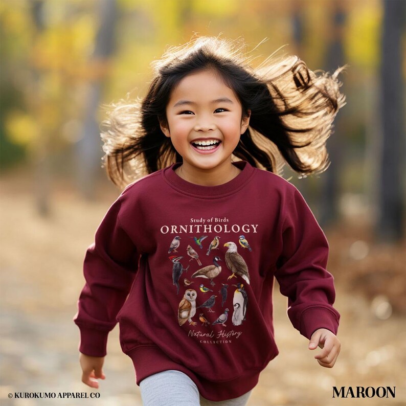May include: A maroon sweatshirt with the text "Study of Birds ORNITHOLOGY" and various bird illustrations. The sweatshirt is part of the "Natural History Collection". The word "MAROON" is printed on the bottom right.