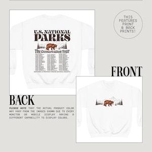 May include: White sweatshirt with a brown bear graphic and text "U.S. National Parks The Conservation Tour". The back of the sweatshirt has a list of tour locations. The front and back of the sweatshirt have prints.