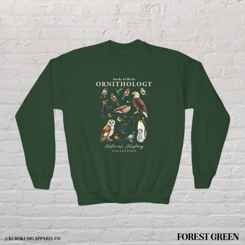 May include: Forest green sweatshirt featuring a detailed illustration of various bird species. The design includes the text "Study of Birds ORNITHOLOGY Natural History Collection". The sweatshirt is a comfortable, long-sleeved garment.