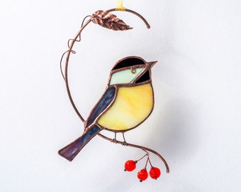 May include: A stained glass bird with blue, yellow, and black wings perched on a copper wire branch with red berries.