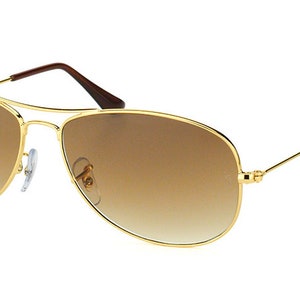 Puede incluir: Gafas de sol aviador doradas con lentes de degradado marr&oacute;n.