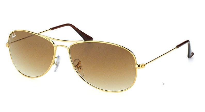 Puede incluir: Gafas de sol aviador doradas con lentes de degradado marr&oacute;n.