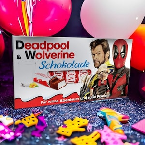 Könnte beinhalten: Eine rechteckige Schachtel Deadpool & Wolverine Schokolade mit einer Abbildung eines Schokoriegels, einem Glas Milch, einem kleinen Hund sowie den Charakteren Deadpool und Wolverine. Die Verpackung enthält den Text Deadpool & Wolverine Schokolade und Für wilde Abenteuer und süße Pausen.