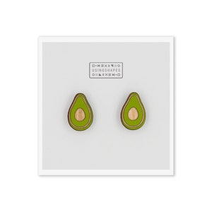 May include: A pair of avocado-shaped wooden earrings with a green and brown color scheme. The earrings are made by the company "Using Shapes".