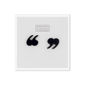 Peut inclure: Une paire de boucles d'oreilles en forme de guillemets noires. Les boucles d'oreilles sont en métal et ont la forme de guillemets. Les boucles d'oreilles sont sur un fond blanc.