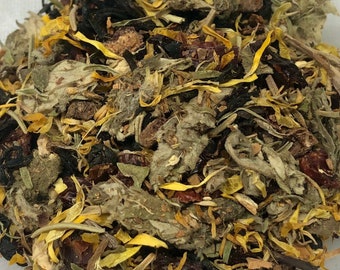 以下が含まれることがあります： 黄色いカレンデュラの花びら、緑のハーブ、濃い茶葉など、乾燥ハーブと花のブレンドのクローズアップ。