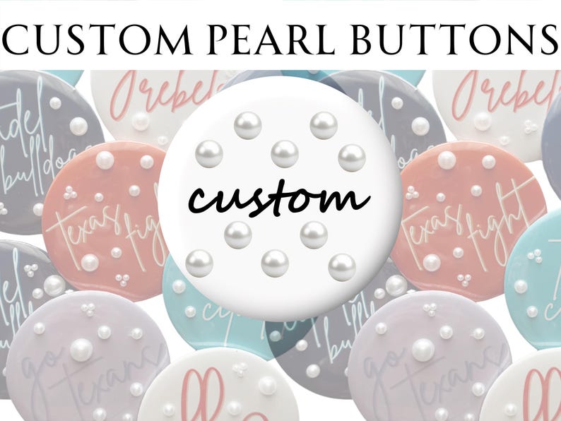 May include: A collection of custom pearl buttons in various pastel colors, including white, pink, and blue. Each button is adorned with multiple pearls and features custom text. The central button has the word "custom" in black script.
