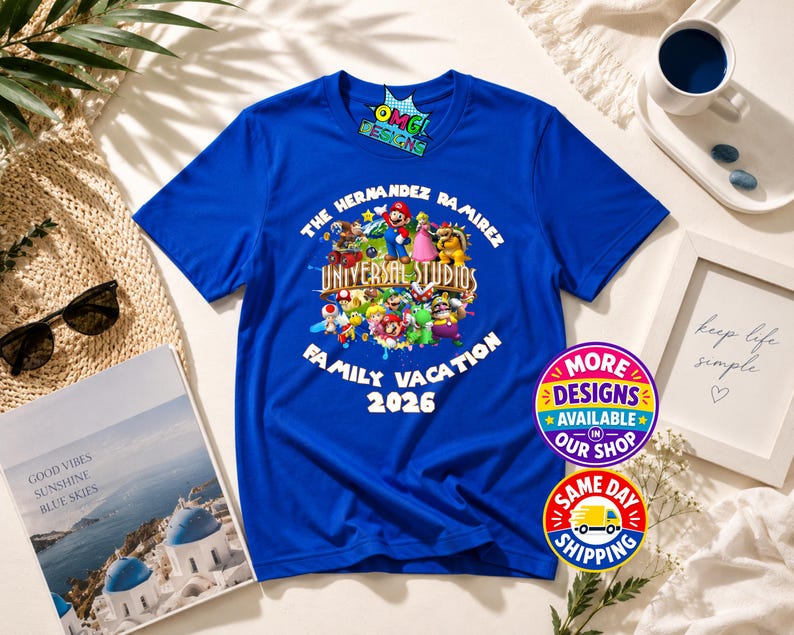 May include: A royal blue short-sleeve t-shirt featuring a graphic print of various Super Mario characters surrounding the text Universal Studios. The shirt includes the custom text The Hernandez Ramirez Family Vacation 2026 printed in white.