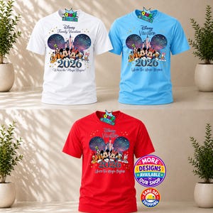 Puede incluir: Tres camisetas de manga corta en blanco, azul claro y rojo. Cada una presenta un gr&aacute;fico de personajes de Disney, un castillo, fuegos artificiales y el texto Disney Family Vacation 2026 Where the Magic Begins. Un peque&ntilde;o logo est&aacute; arriba.
