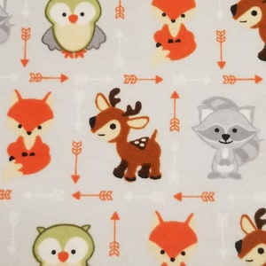 May include: A light gray fabric with a repeating pattern of woodland animals and arrows. The animals include a fox, a deer, an owl, and a raccoon. The arrows are orange and white.