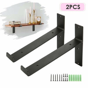 May include: Two black metal shelf brackets with screws and wall plugs. The brackets are L-shaped with a flat base and a raised lip. The image also shows a shelf with decorative items, including candles and a clock. The text "2PCS" is in a pink rectangle.