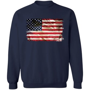 May include: A navy blue sweatshirt with a distressed American flag graphic printed on the front.