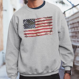 May include: A gray sweatshirt with a vintage-style American flag printed on the front.