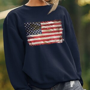 May include: A navy blue sweatshirt with a distressed American flag graphic printed on the front.