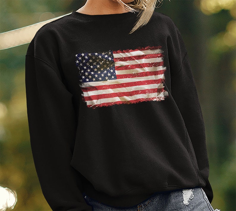 May include: Black sweatshirt with a distressed American flag graphic printed on the front.