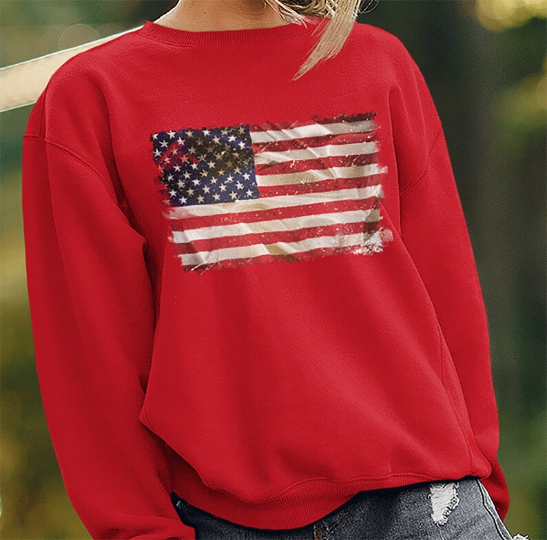 May include: Red sweatshirt with a distressed American flag graphic print.
