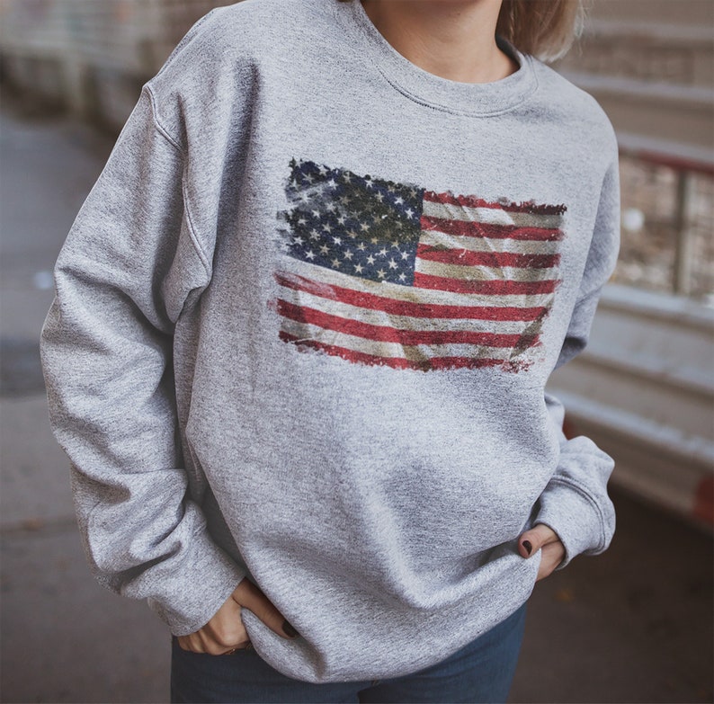 May include: A gray sweatshirt with a distressed American flag print.