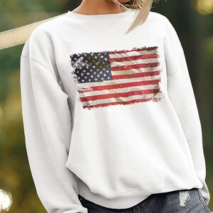 May include: White sweatshirt with a distressed American flag print.