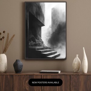 Puede incluir: Impresi&oacute;n art&iacute;stica en blanco y negro de una escalera que conduce a un paisaje arquitect&oacute;nico brumoso. La impresi&oacute;n enmarcada se muestra sobre un mueble de madera. El texto "NEW POSTERS AVAILABLE" se muestra en un &oacute;valo negro.