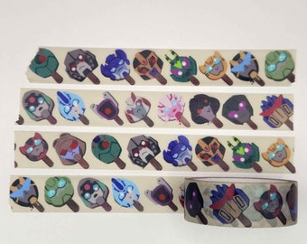 May include: A roll of washi tape with a repeating pattern of cartoon robot heads on popsicle sticks. The tape is beige with brown popsicle sticks and colorful robot heads. The tape is partially unrolled, showing the pattern.