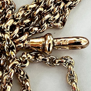 Puede incluir: Primer plano de una cadena de oro con un cierre. El cierre está marcado con el número "585".