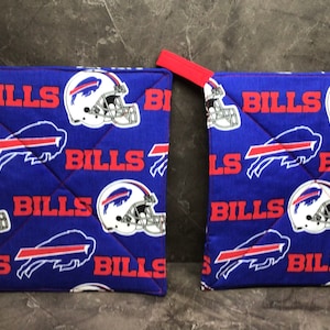 May include: Two blue and red pot holders with a Buffalo Bills logo and the word "Bills" repeated on them.