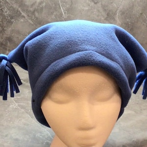 May include: A blue fleece hat with two long tassels on the sides. The hat is made of soft, warm fleece and is perfect for keeping your head and ears warm in the winter.