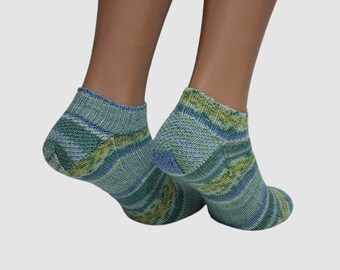 May include: A pair of ankle socks in shades of blue, green, and yellow. The socks have a textured knit pattern and a ribbed cuff. The socks are displayed on a mannequin's legs against a plain background.