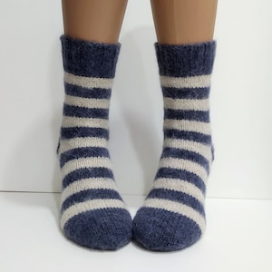 May include: A pair of blue and white striped socks made of wool. The socks are knitted and have a fuzzy texture.