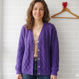 Puede incluir: Una taza de cerámica blanca con un asa negra y el texto "But First, Coffee" en negrita negra. La taza se encuentra sobre un fondo neutro, resaltando su diseño simple.