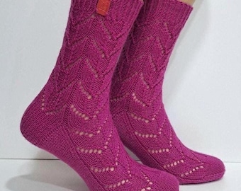 May include: A pair of pink knitted socks with a lacy pattern. The socks are made with a delicate yarn and have a soft, comfortable feel.