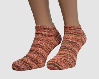 May include: A pair of ankle socks with a striped pattern in shades of brown, orange, and red.