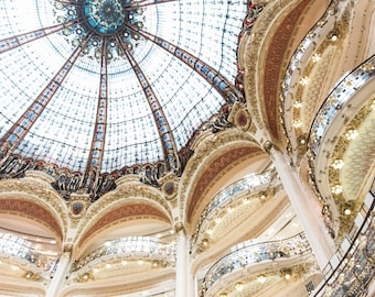 May include: A view of the ornate interior of a building with a large glass dome ceiling and multiple levels of balconies. The dome is decorated with intricate stained glass patterns and the balconies are adorned with gold accents.