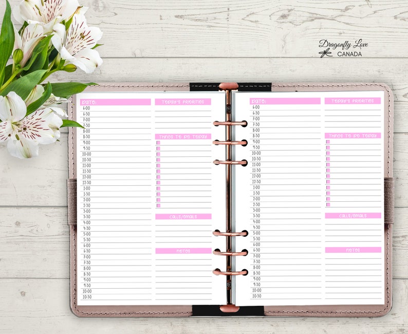 May include: Open planner with pink accents and a rose gold binding. The planner pages are organized with sections for the date, to-do lists, calls/goals, and notes. The top right corner has the text "Dragonfly Love CANADA".