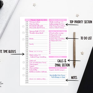 May include: A pink and white planner page with a detailed daily schedule, including time blocks, to-do lists, and notes. The page is surrounded by a pen, a wooden bowl with paper clips, and a black notebook. The planner has the text "Dragonfly Love Canada".