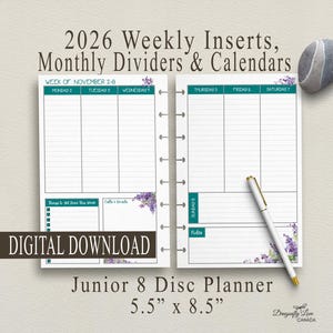 May include: A planner with weekly inserts, monthly dividers, and calendars for 2026. The Junior 8 Disc Planner measures 5.5" x 8.5". The design includes teal accents and floral details. A pen and a decorative stone are also present.