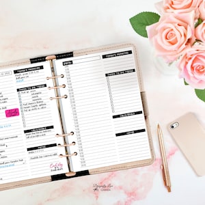May include: A beige planner open to a daily schedule, with a gold pen and phone. The planner's pages are filled with handwritten notes and to-do lists. Pink roses in a vase are in the background.