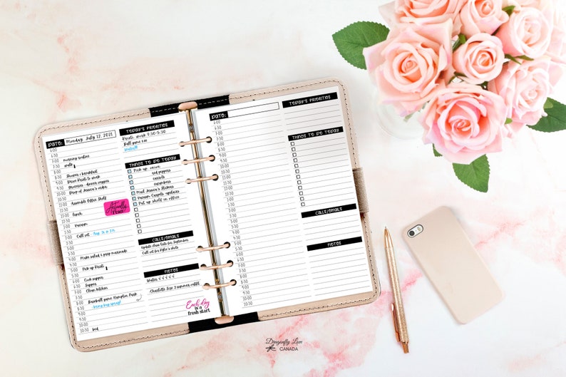 May include: A beige planner open to a daily schedule, with a gold pen and phone. The planner's pages are filled with handwritten notes and to-do lists. Pink roses in a vase are in the background.