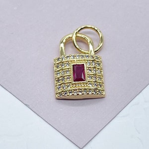May include: Gold padlock charm with a red gemstone and clear rhinestones.