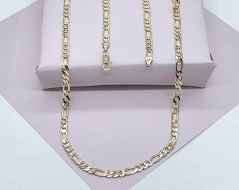 May include: Three gold chains of different lengths, all with a classic figaro design. The chains are laid out on a pink surface.
