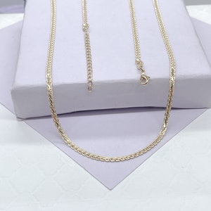 May include: A gold chain necklace with a delicate, braided design. The chain is on a white surface.