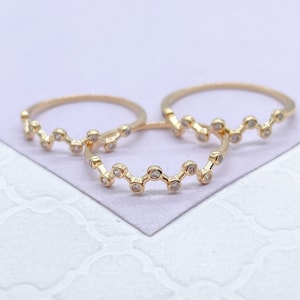 May include: Three gold rings with a wavy design and small clear stones.