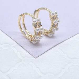 May include: A pair of gold hoop earrings with a double row of faux pearls and clear rhinestones.