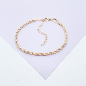 May include: A gold-toned rope chain bracelet with a lobster clasp closure.