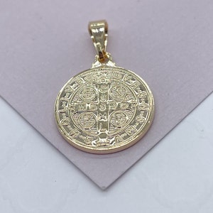K&ouml;nnte beinhalten: Ein goldfarbener Anh&auml;nger mit einem detaillierten kreisf&ouml;rmigen Design. Der Anh&auml;nger hat oben eine Schlaufe f&uuml;r eine Kette und aufwendige gepr&auml;gte Muster und Text. Der Anh&auml;nger ist wahrscheinlich aus einem goldfarbenen Metall gefertigt.